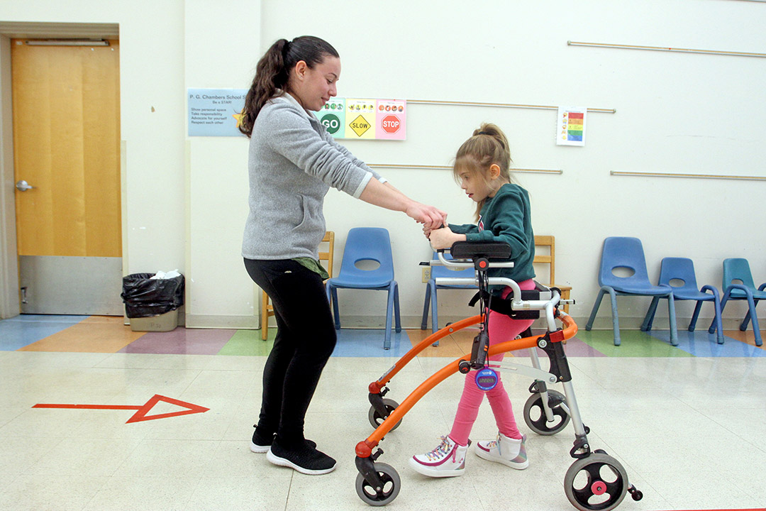 Male elementary student in a wheelchair laughing with his classmates