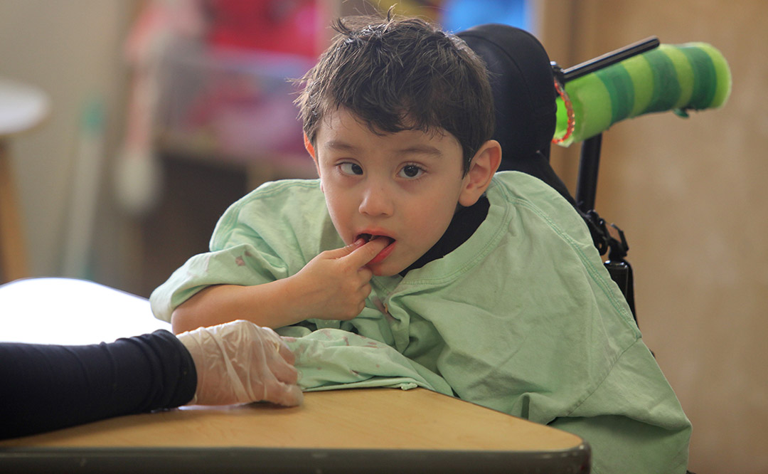 Younger male student working on therapeutic mealite with a therapist